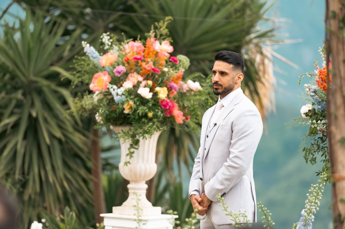 groom in gray suit at colorful wedding ceremony