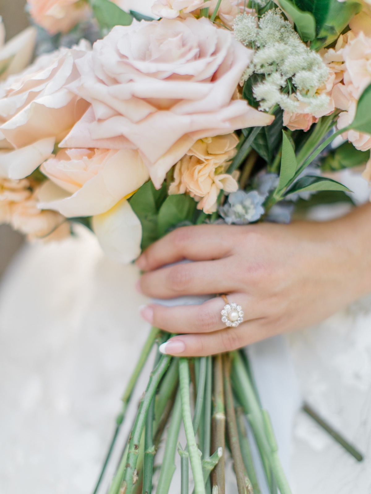 pastel wedding bouquet with pearl engagement ring