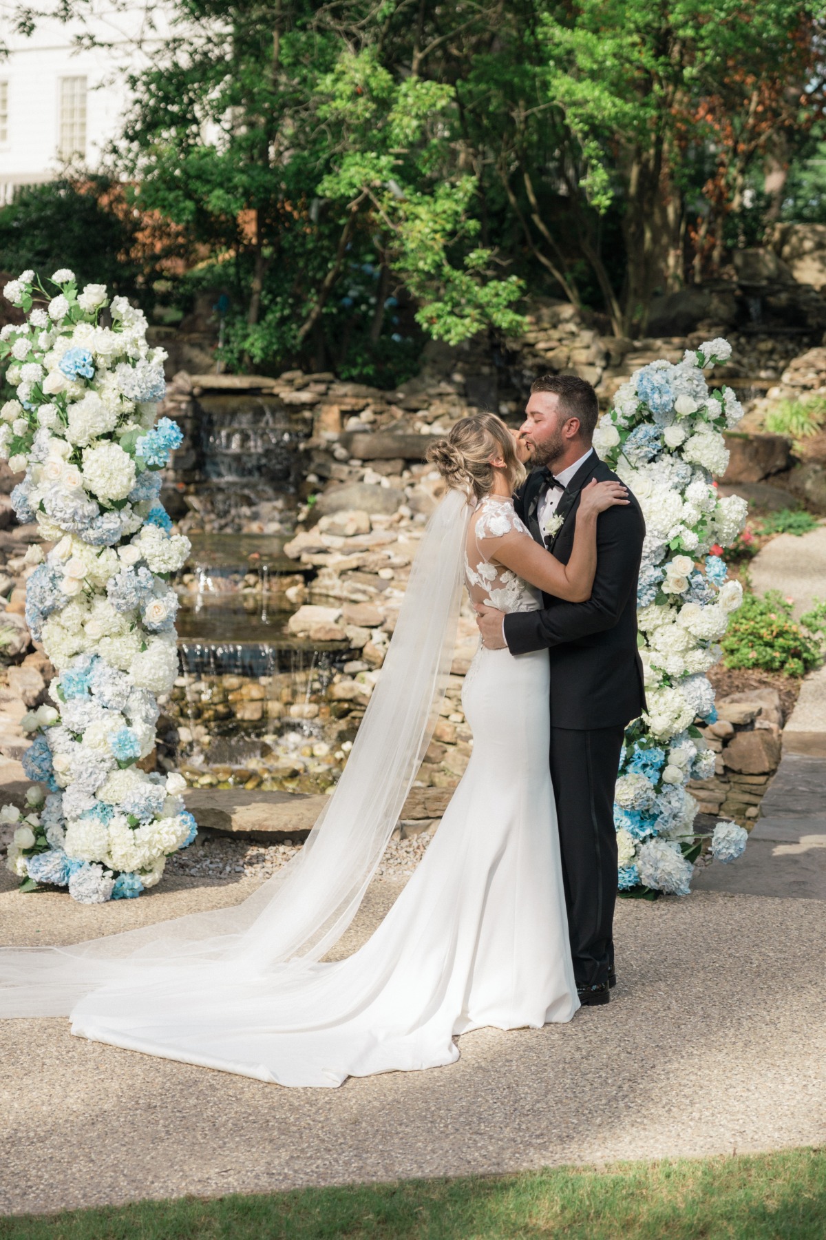 bride and groom kiss at garden wedding ceremony