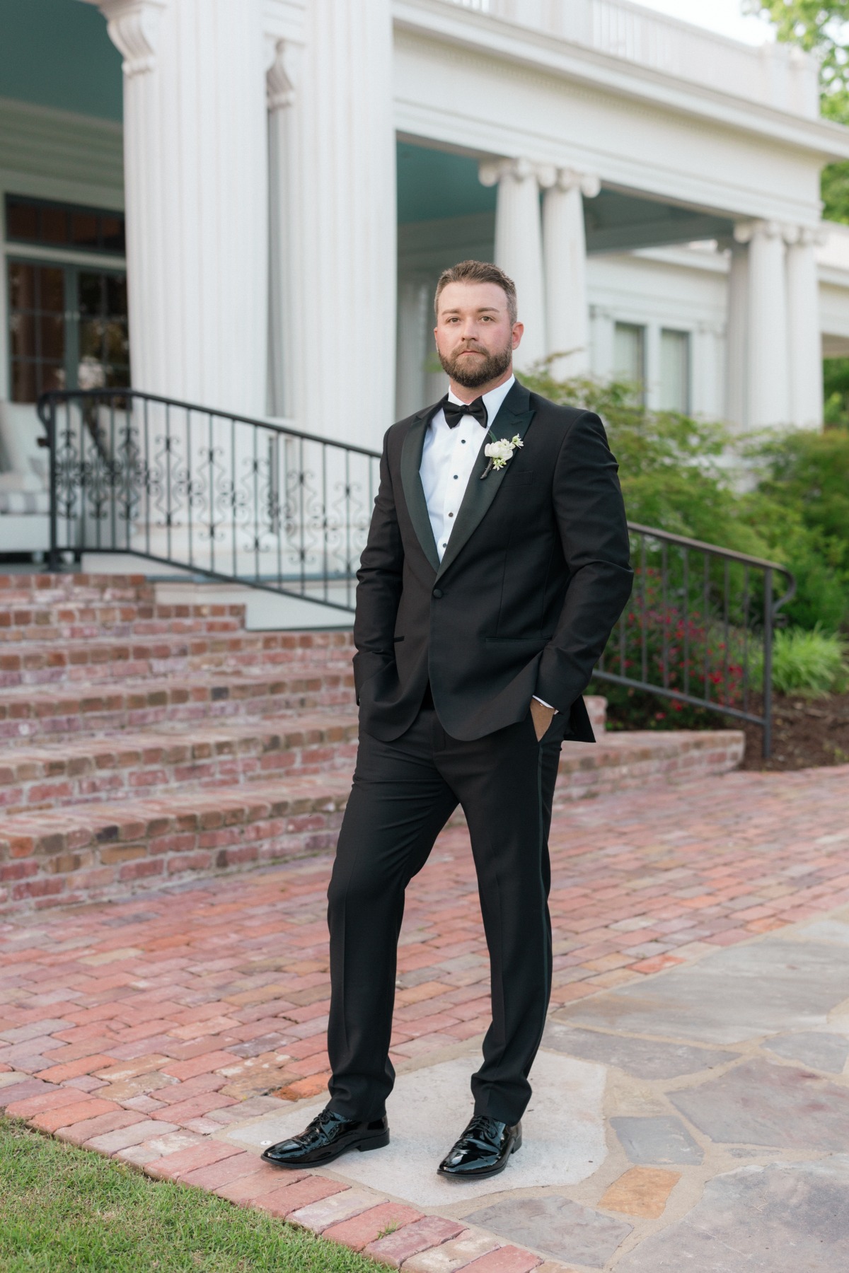 groom in black tuxedo at mansion