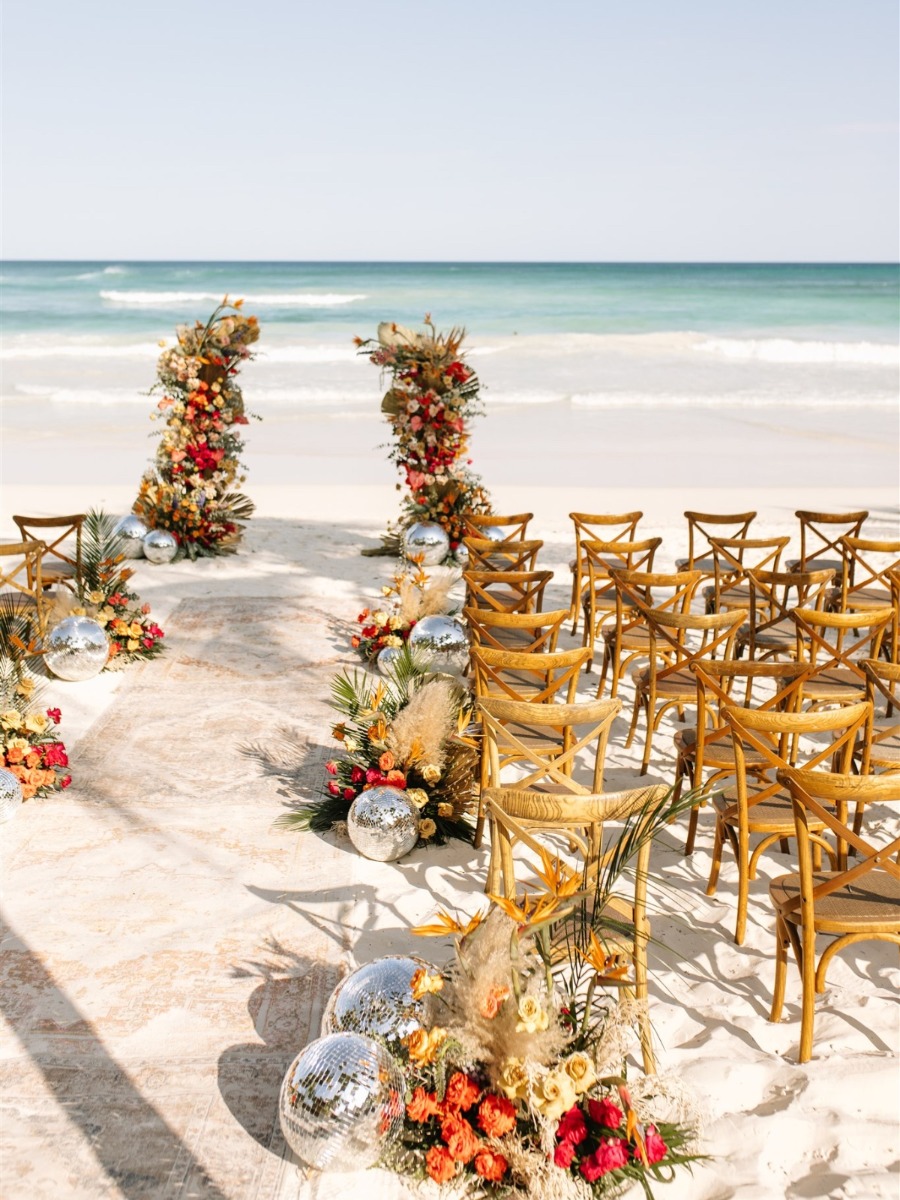 Disco beach wedding in tulum with plenty of flowers and pops of color