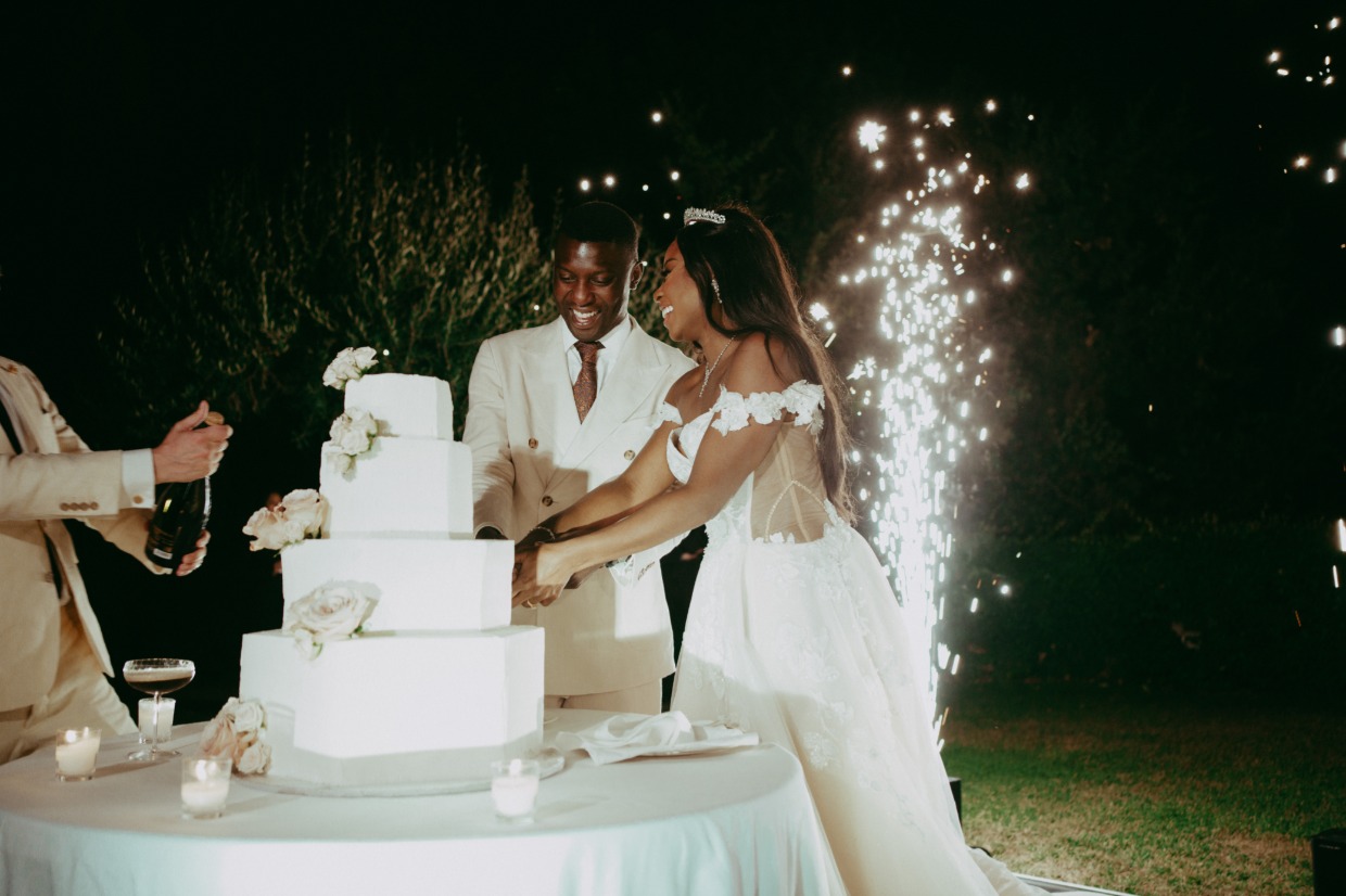 bride in euphoria by galia lahav cutting wedding cake